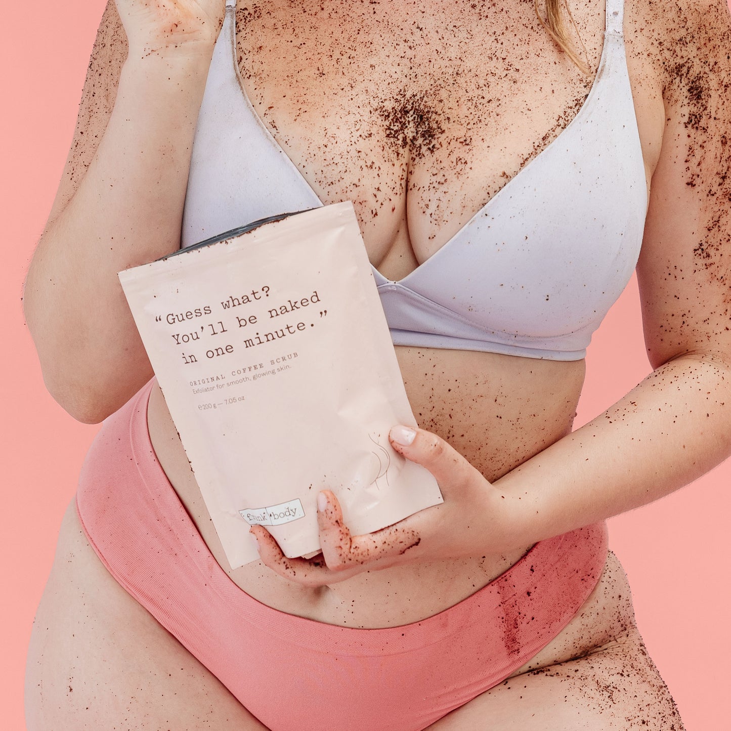 Person holding a Frank Body coffee scrub with text on a pink background