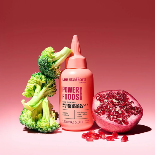 Lee Stafford Power Foods hair treatment bottle with broccoli and pomegranate on a red background